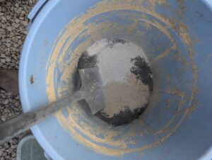 バケツで米ぬか・腐葉土・卵の殻を混ぜている様子